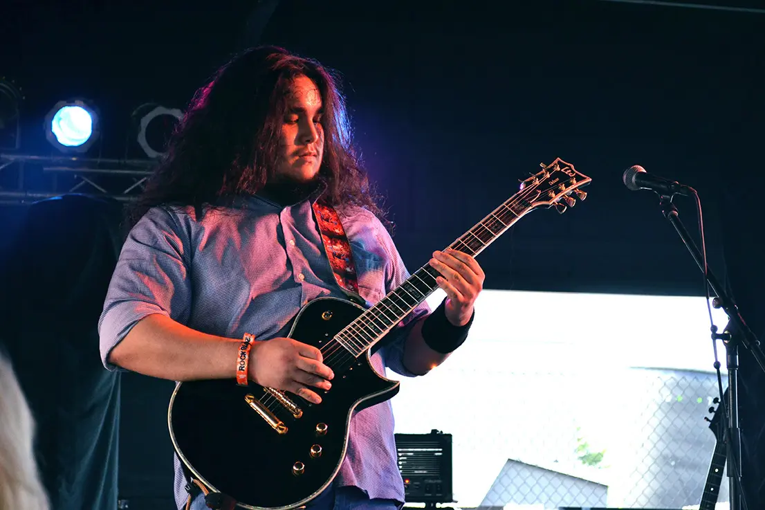 Live photo of the guitarist from Chicago hard rock band Aeraco playing on a black LTD guitar at Rock Fest 2016
